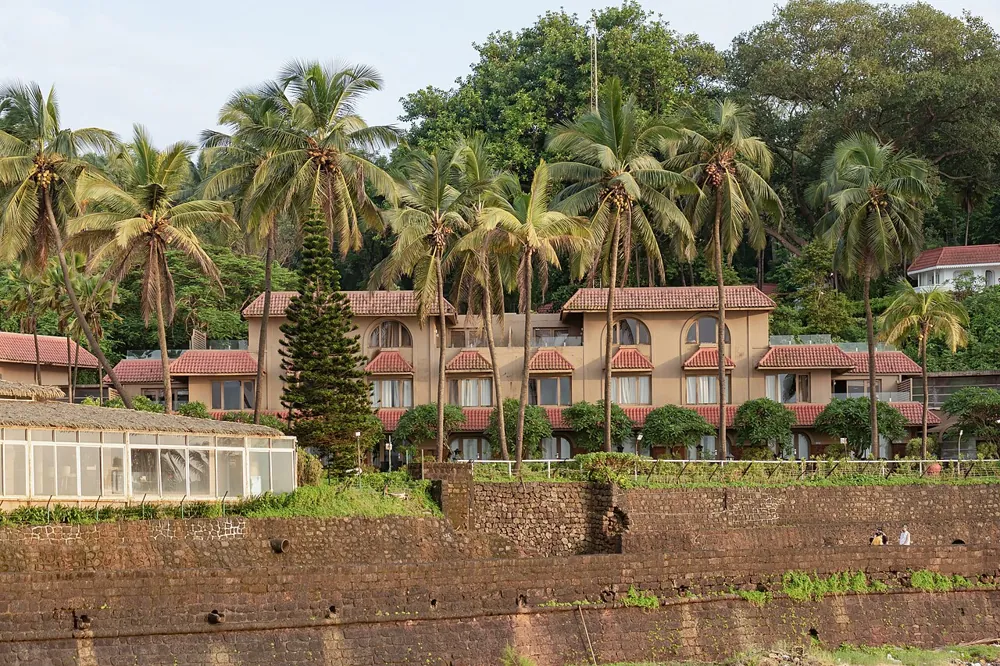 Taj Fort Aguada Resort cottages among palm trees in Goa